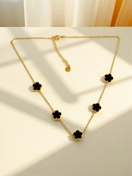 Collier Perséphone Aurea avec des fleurs noires sur une chaîne plaquée or