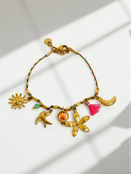 Bracelet Callisto avec des breloques sur le thème du soleil, de l'oiseau et de la fleur