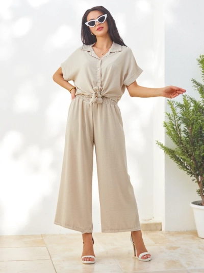 Ensemble Royalfashion pour femmes avec une chemise à manches courtes nouée et un pantalon évasé avec des strass
